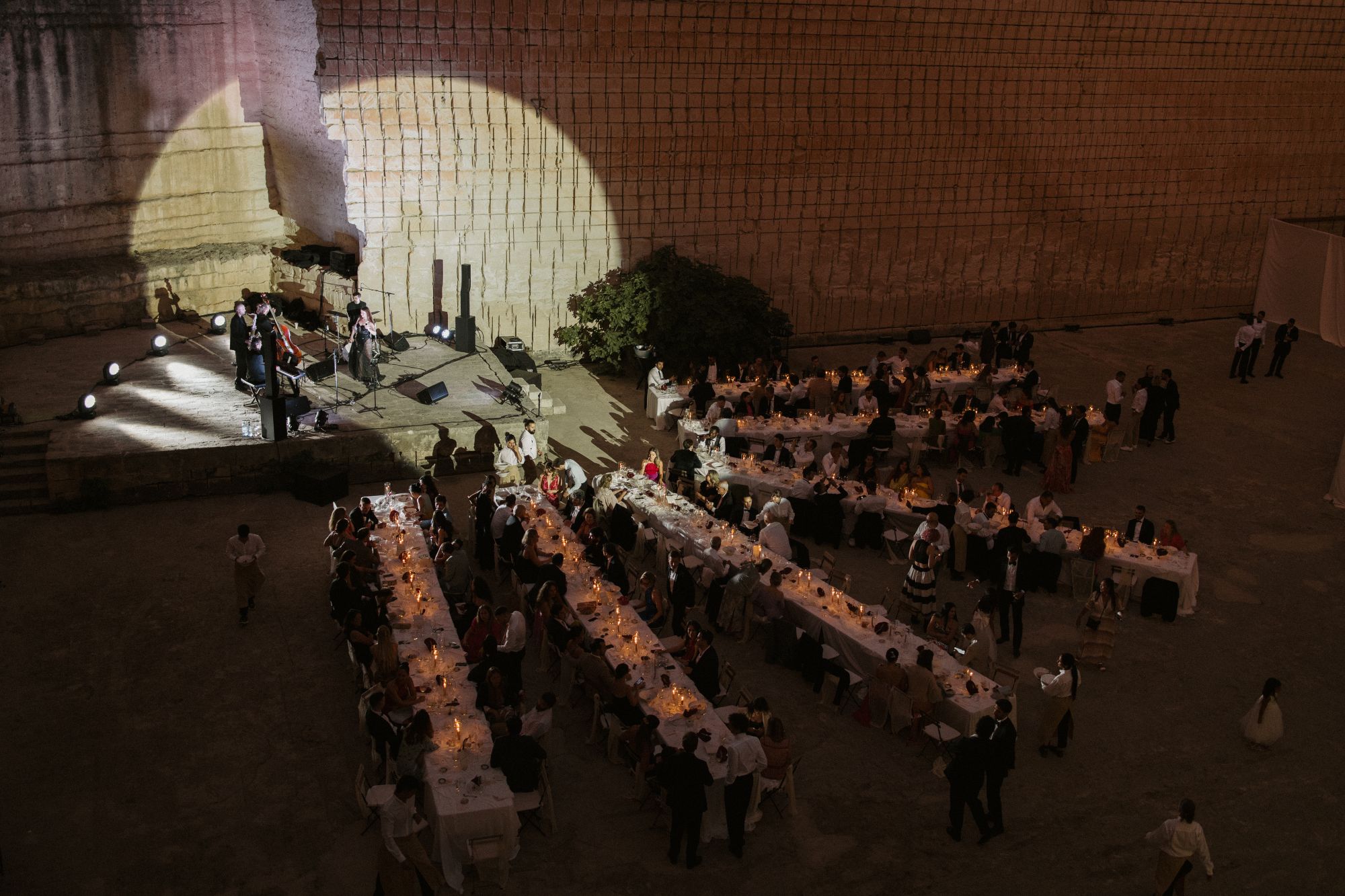 Live-Musik neben kerzenbeleuchteten Dinner-Tischen bei einem abendlichen Empfang